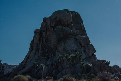 Low angle view of rock formation against sky at night