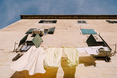 Low angle view of clothes drying against building