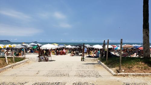 People at beach against sky