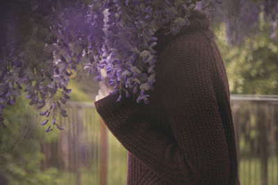 Close-up of woman against purple flowers