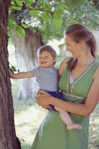 Woman with arms raised against trees