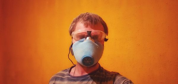 Portrait of young man against orange wall