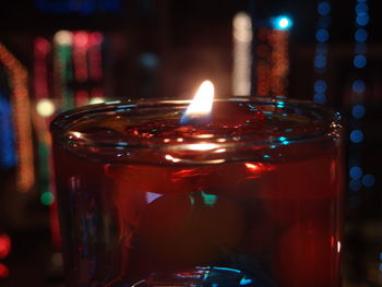 Close-up of lit diya in glass container at night during diwali