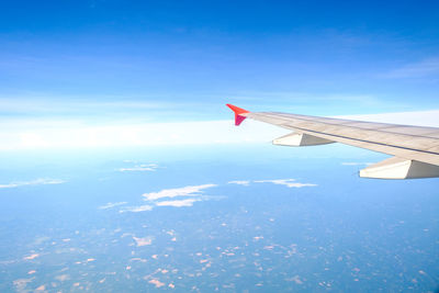 Aerial view of airplane wing against blue sky