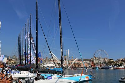 Sailboats moored in harbor against sky