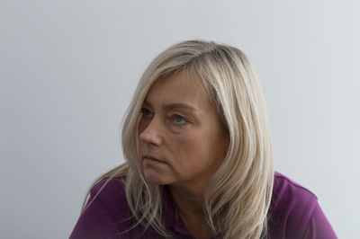 Close-up of woman looking away against white background