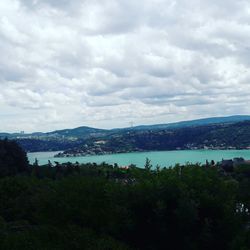 Scenic view of river against cloudy sky