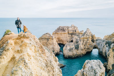 People on cliff against sea