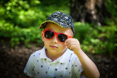 Portrait of young woman wearing sunglasses standing outdoors