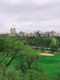 Park by buildings against sky in city