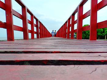 Surface level of red bridge against sky in city