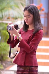 Beautiful young woman photographing with mobile phone