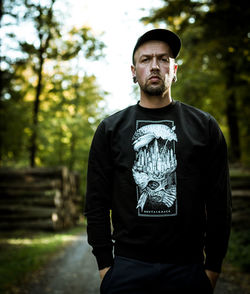 Portrait of young man standing in forest