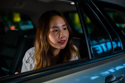 Portrait of young woman sitting in car