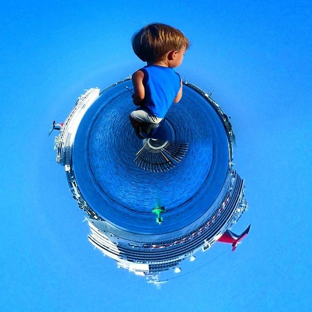 LOW ANGLE VIEW OF WOMAN AGAINST CLEAR BLUE SKY