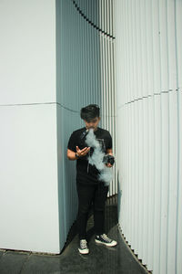 Young man standing against wall