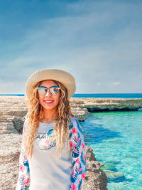 Portrait of smiling young woman standing on beach