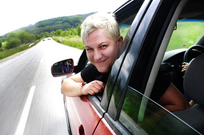 Portrait of woman peeking from car window