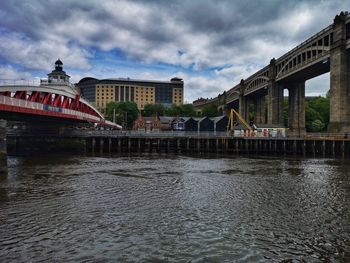 Bridge over river against buildings in city