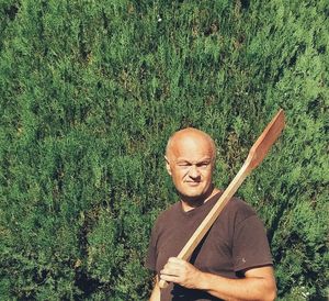 Man holding oar against plants