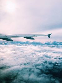 Cropped image of airplane flying over clouds