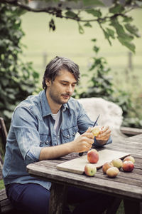 Man peeling apples at table in organic farm