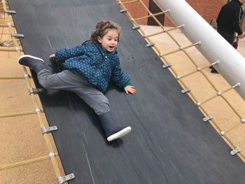 High angle view of girl sliding on slide at playground