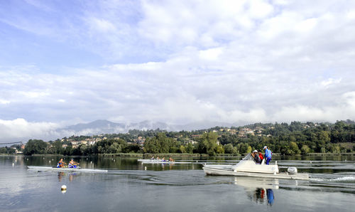 People on lake against sky