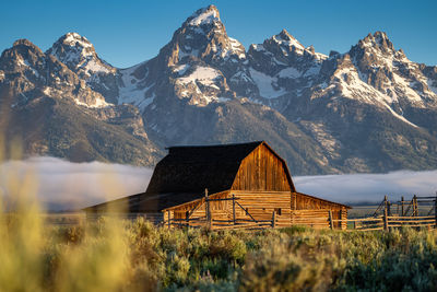 Built structure on snowcapped mountain against sky