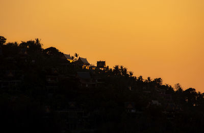Silhouette buildings against sky during sunset