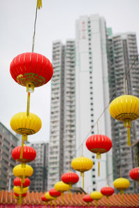 Low angle view of lanterns hanging against buildings in city