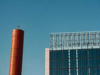 Low angle view of modern building against clear blue sky