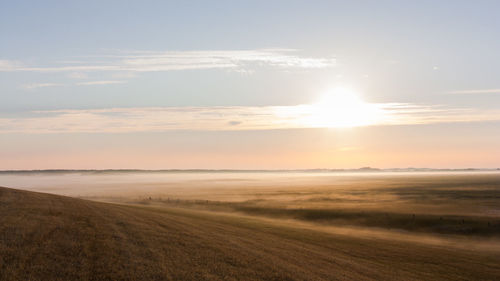 Scenic view of field against sky during sunset