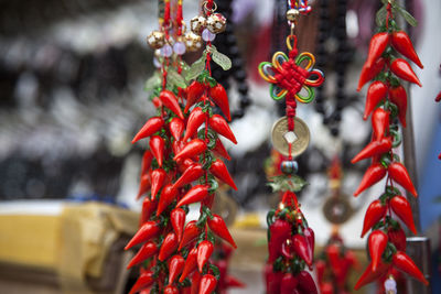 Close-up of red chili key ring charms hanging at market stall