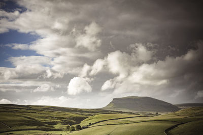 Panoramic view of agricultural field against sky