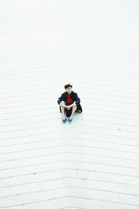 Full length of young man using mobile phone while standing outdoors