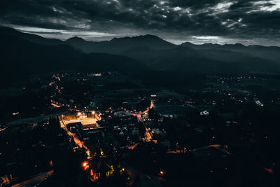 High angle view of illuminated city against sky at night