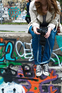 Full length of woman with multi colored graffiti