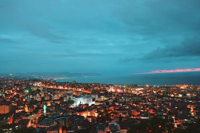 High angle shot of illuminated cityscape against sky at dusk