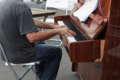 Midsection of man playing piano