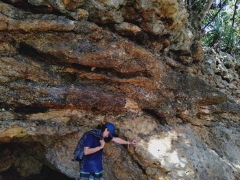 Malang, indonesia - 1 november 2020, a man posing in front of a cliff during summer vacation.