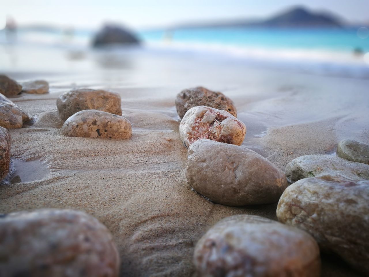 beach, sea, water, land, solid, no people, rock, selective focus, nature, rock - object, day, beauty in nature, tranquility, sand, close-up, stone, surface level, outdoors, pebble
