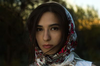 Close-up portrait of young woman wearing scarf at park