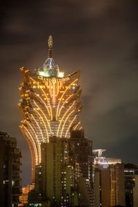 Low angle view of illuminated buildings against sky at night