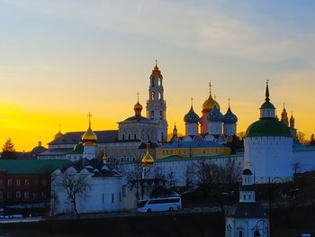 Buildings in city against sky during sunset