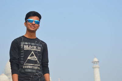 Portrait of man standing against clear blue sky