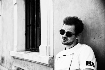 Portrait of young man standing against wall