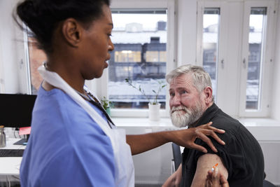 Female doctor vaccinating senior patient