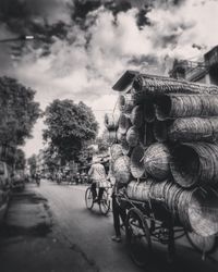 Bicycles on street in city against sky