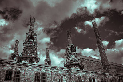 Low angle view of buildings against cloudy sky